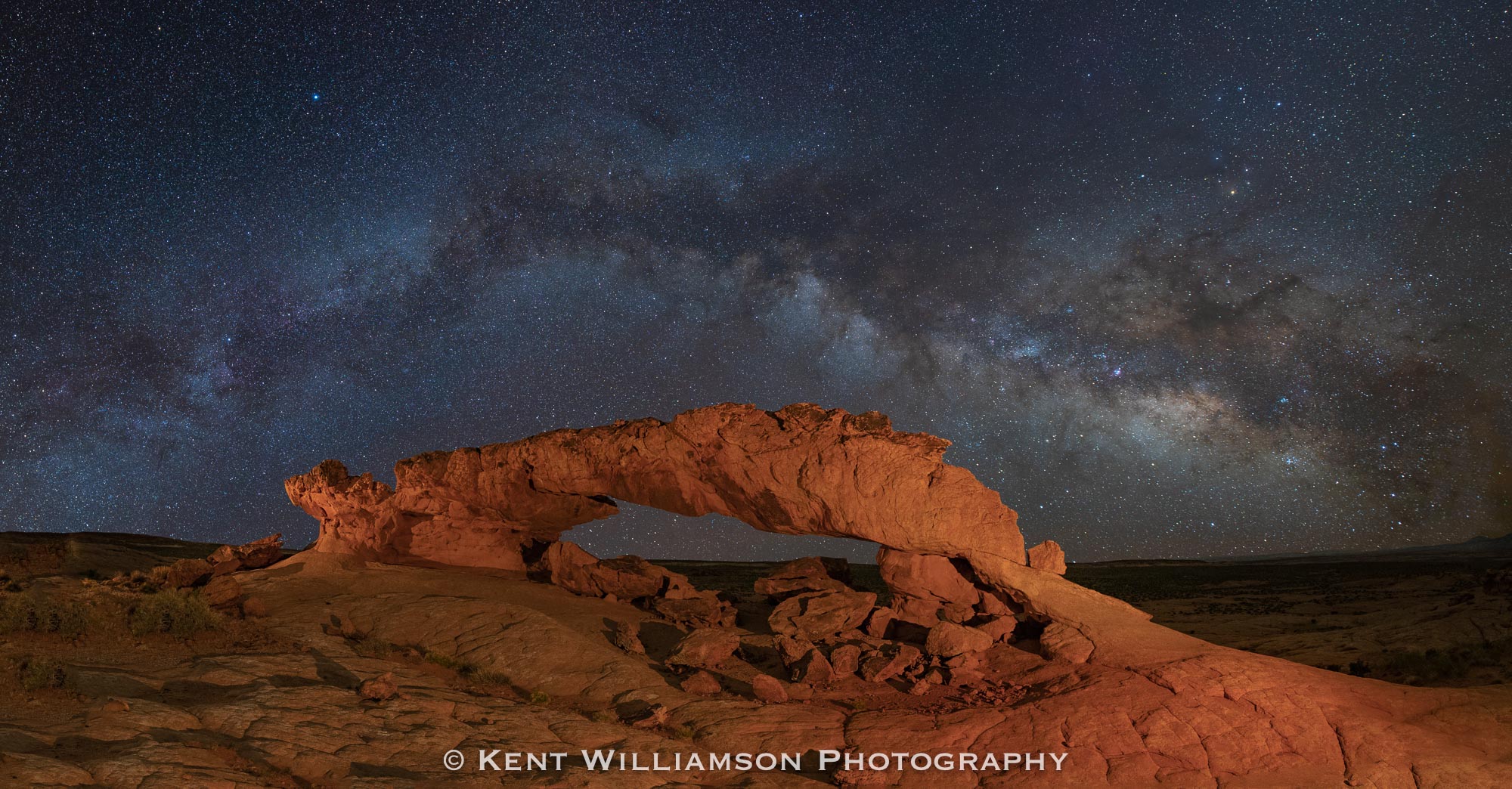 A clear night over Sunset Arch in Escalante Utah.  This image is a nighttime panorama, and has an aspect ratio of 1:192-- the...