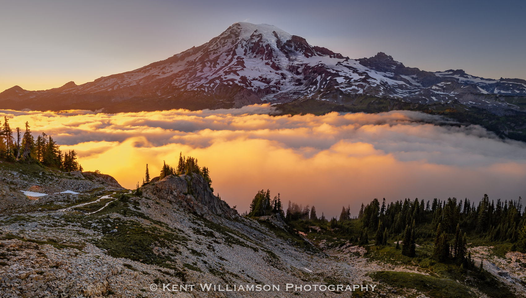 Sunset Below Mt Rainier The setting sun illuminates clouds in the valley below Mt Rainier. I took this image from high in the Tatoosh range across the...